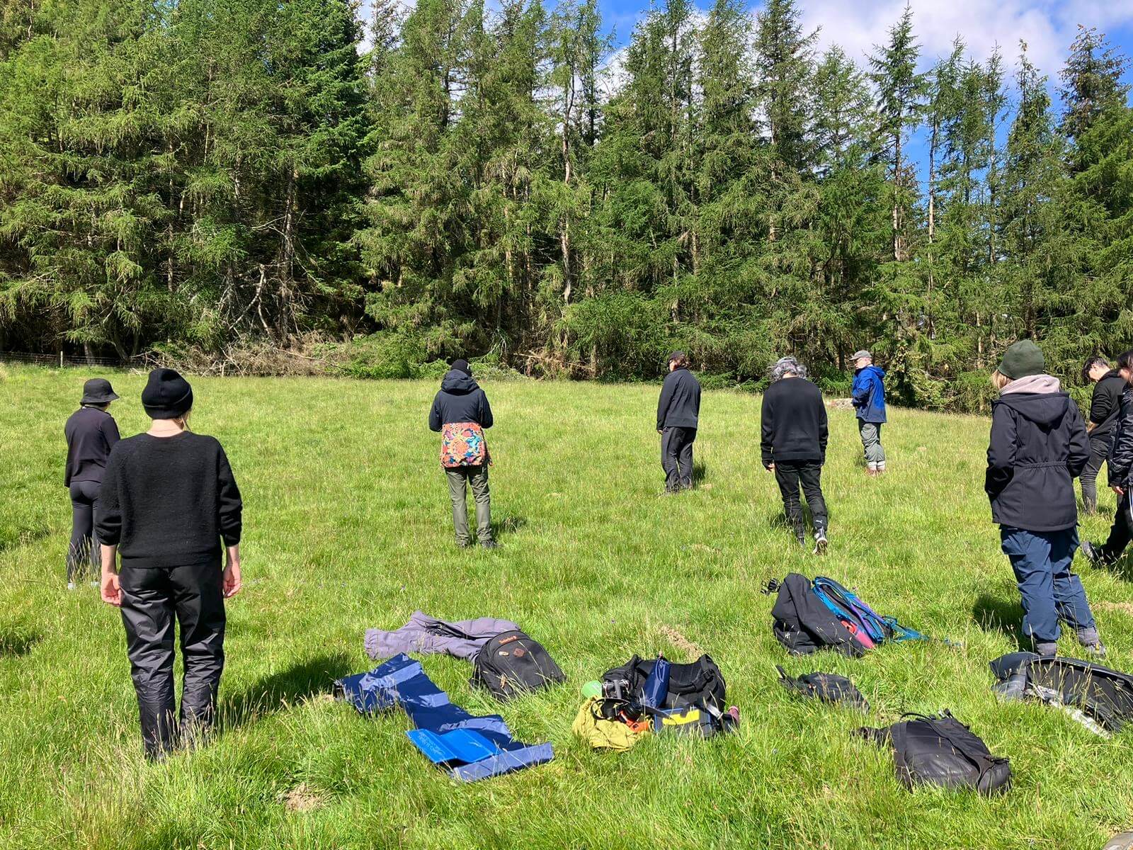 Människor som står på en äng.